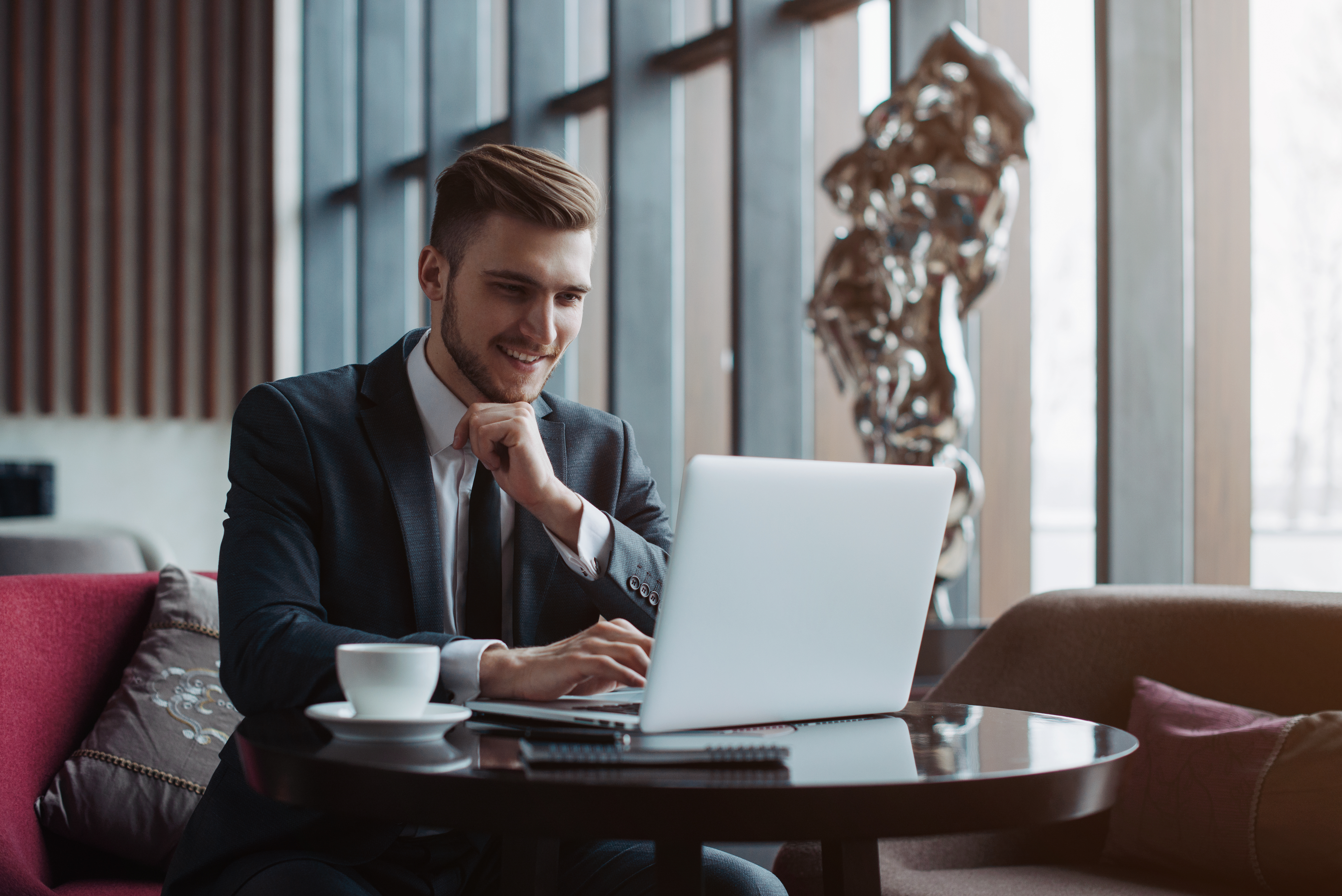 man smiling in front of his laptop